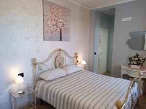 a bedroom with a bed with a white and pink bedspread at B&B VILLA PREZIOSA LAGO MAGGIORE in Lesa