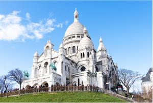 um grande edifício branco no topo de uma colina em Magnifique Appart proche Paris Gare 4pers wifi-clim em Argenteuil