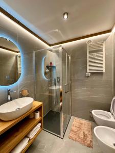 a bathroom with a shower and two sinks and a toilet at Cozy bilocale apartment in Breuil-Cervinia