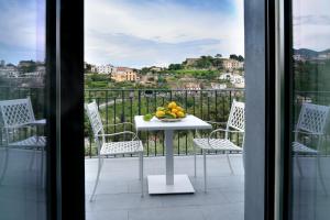 a table with a bowl of fruit on a balcony at Residence Villa Ruocco in Scala