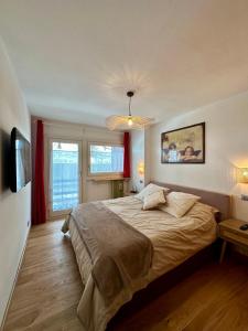 a bedroom with a large bed and a large window at Cozy bilocale apartment in Breuil-Cervinia