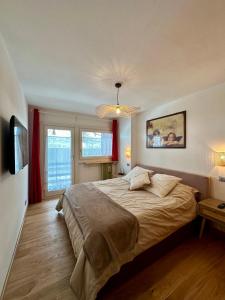 une chambre avec un grand lit et une grande fenêtre dans l'établissement Cozy bilocale apartment, à Breuil-Cervinia