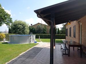 een patio met een tafel en een zwembad bij Montericco House in Mondavio