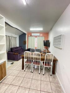 Residência Gramal do Campeche في فلوريانوبوليس: غرفة معيشة مع طاولة وكراسي وأريكة