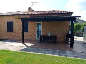 een paviljoen met een picknicktafel en een bank bij Montericco House in Mondavio