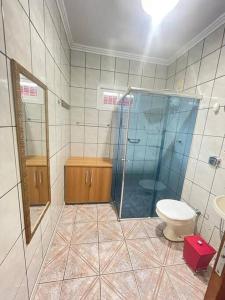 uma casa de banho com um WC e uma cabina de duche em vidro. em Residência Gramal do Campeche em Florianópolis