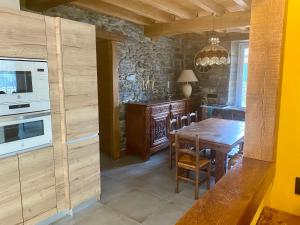 una cucina con tavolo in legno e piano cottura forno superiore di Fondamaria - Alojamiento rural a Lesaka