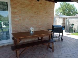 een picknicktafel en een grill op een patio bij Montericco House in Mondavio