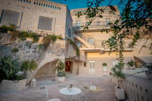 a courtyard of a building with plants and tables at Tufo Bianco Relais in Massafra