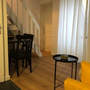 a living room with a table and a chair at Joli duplex in Dijon
