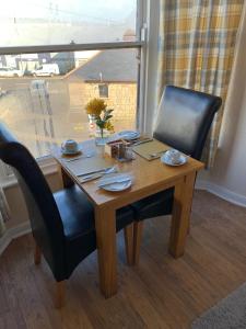 a wooden table with two chairs and a window at The Dock Inn in Penzance