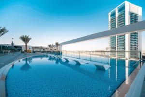 a large swimming pool in front of a building at HiGuests - Bella Rose Studio With Stunning Desert Views in Dubai
