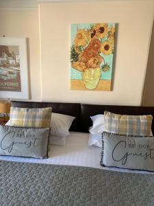 a bed with two pillows and a painting on the wall at The Dock Inn in Penzance