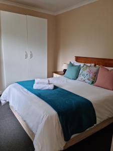 a bedroom with a large bed with towels on it at Little Louisa in Port Elizabeth