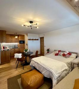 a bedroom with a bed and a table and a kitchen at Cozy bilocale apartment in Breuil-Cervinia