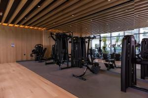 a gym with several treadmills and exercise bikes in a room at HiGuests - Bella Rose Studio With Stunning Desert Views in Dubai