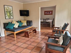ein Wohnzimmer mit einem Sofa und einem Tisch in der Unterkunft Little Louisa in Port Elizabeth