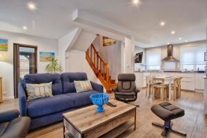 a living room with a blue couch and a table at La Casa Bella - Calm and cosy house by the sea in Ouistreham