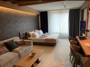 a hotel room with a bed and a couch at Woodside Residences Ski&Spa in Kopaonik +16 photos