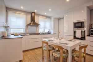 uma cozinha com uma mesa branca e cadeiras numa cozinha em La Casa Bella - Calm and cosy house by the sea em Ouistreham