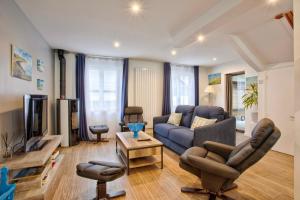uma sala de estar com um sofá e uma televisão em La Casa Bella - Calm and cosy house by the sea em Ouistreham