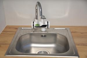 a stainless steel kitchen sink with a faucet at Be Solei Studio Apartments Sol 1 in Tirana