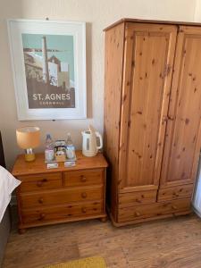 a bedroom with a wooden cabinet and a wooden dresser at The Dock Inn in Penzance