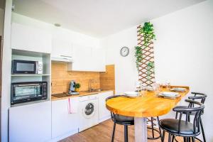 a small kitchen with a wooden table and chairs at 21 Centre Historique - Gare- Place de la Comédie in Montpellier