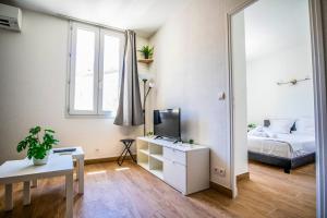 a small room with a bed and a television at 21 Centre Historique - Gare- Place de la Comédie in Montpellier +3 photos