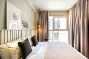9 Muses Exclusive Suites In Syntagma في أثينا: غرفة نوم بسرير ونافذة كبيرة