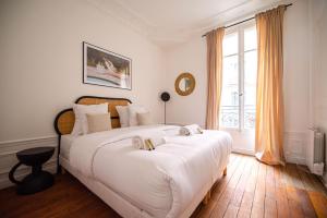a bedroom with a large bed and a window at Residence Gustave Eiffel - PARIS in Paris