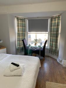 a room with a bed and a table and a window at The Dock Inn in Penzance