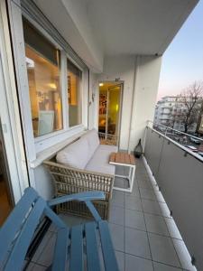d'un balcon avec une chaise bleue et une fenêtre. dans l'établissement Zimtstern-West, à Stuttgart