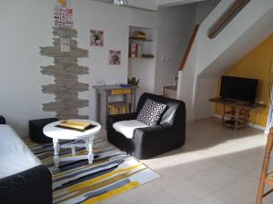 - un salon avec un canapé et une chaise dans l'établissement Maison de vacances Sol & Piper, à Gombergean