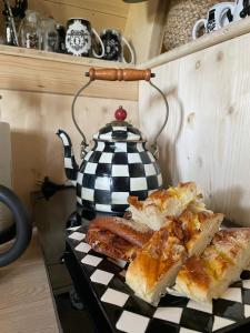 un bollitore per il tè e fette di pane su un tavolo di Fairytale tinyhouse near the sea - Häxans hus a Gothem