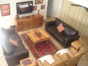 Una sala de estar con dos sofás y un televisor. en Waterside Living MM1404, en Jeffreys Bay