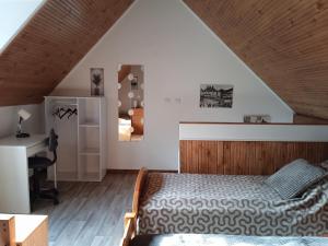 sypialnia z łóżkiem i biurkiem w obiekcie Maison de vacances Sol & Piper w mieście Gombergean
