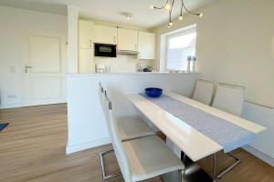 uma cozinha com uma mesa de jantar e cadeiras em Haus Gorch-Fock, App 1 em Westerland