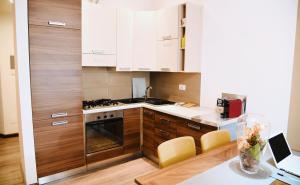 a kitchen with white cabinets and a table with a laptop at Cozy and Elegant Apartment in Rome in Rome