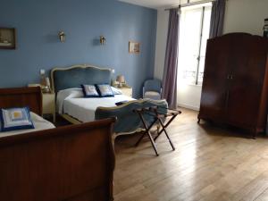 a bedroom with a bed and a chair and a window at La brasserie chambre d'hotes de Delphine in Saulgé