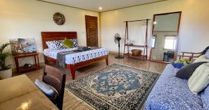 a living room with a bed and a mirror at Beautiful 2BD Farmhouse for 6pax in Ormoc