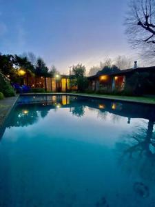 una gran piscina de agua en un patio por la noche en casa Pucón, en Pucón