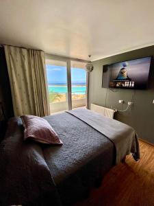 a bedroom with a bed with a view of the ocean at Departamento condominio Laguna del Mar in La Serena