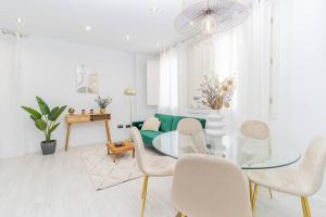 een woonkamer met een glazen tafel en witte stoelen bij Luxury Duplex Plaza del Pilar in Zaragoza