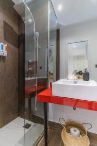 a bathroom with a sink and a glass shower at Luxury Duplex Plaza del Pilar in Zaragoza