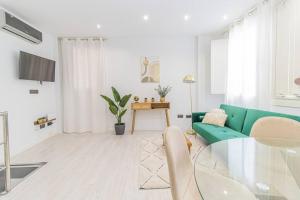 uma sala de estar com um sofá verde e uma mesa de vidro em Luxury Duplex Plaza del Pilar em Zaragoza