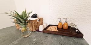 a wooden tray with three bottles and a plant on a counter at Maidi Homestay Mui Ne in Mui Ne