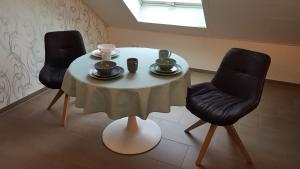 uma mesa com duas cadeiras e uma mesa com duas chávenas em Ferienhaus Fee em Erbach
