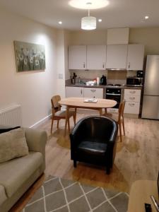 uma sala de estar e cozinha com uma mesa e um sofá em Maidstone Heights By Kasar Stays em Kent