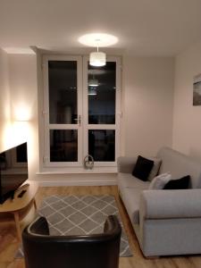 uma sala de estar com um sofá e uma cadeira em Maidstone Heights By Kasar Stays em Kent